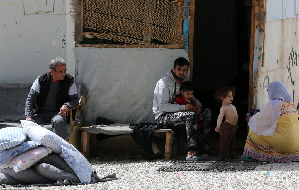 2018年4月12日,在希腊雅典以北约86公里处的里措纳难民营,一对夫妇照顾孩子。新华社发(马里奥斯·罗洛斯摄)