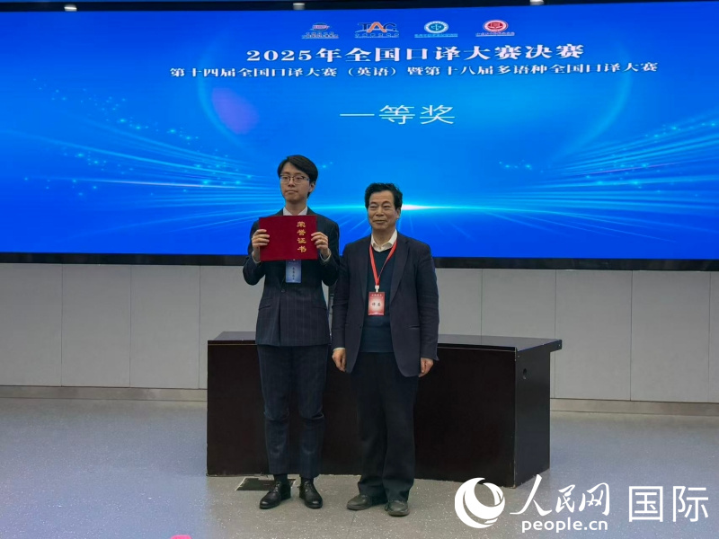 1. 全国俄语交替传译决赛评委会主席李俊升(右)为第一名获奖者刘睿劼(左)颁奖。人民网记者杨倩 摄