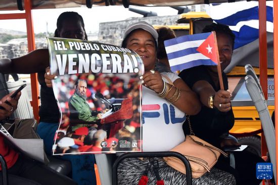 4月2日，民众手持已故古巴革命领袖菲德尔·卡斯特罗的海报在古巴哈瓦那海滨大道参加反对帝国主义、捍卫古巴革命的游行活动。新华社发（华金·埃尔南德斯 摄）